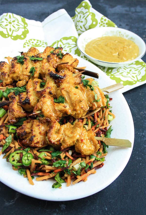 A plate of Cashew Chicken Satay with Carrot and Coriander Salad on a table