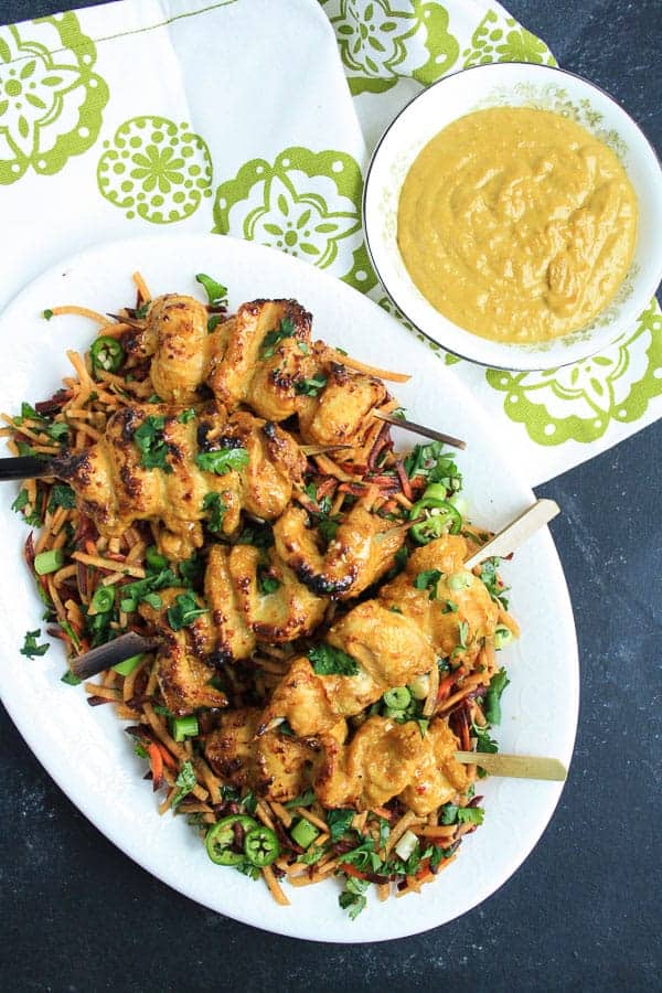 A plate of Cashew Chicken Satay with Carrot and Coriander Salad on a table