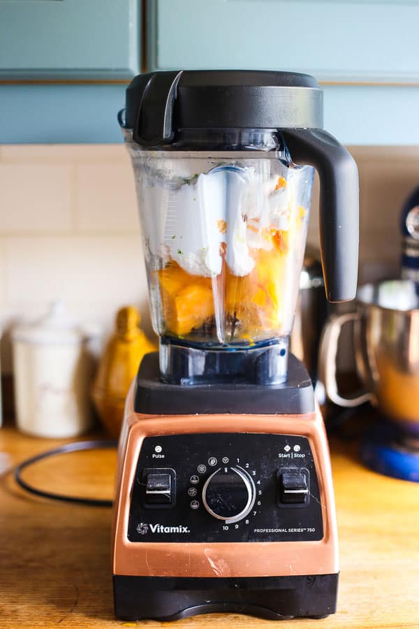 A blender with fro yo in it sitting on a kitchen counter