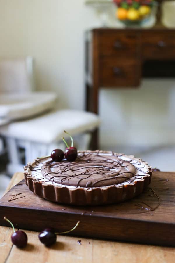 No-Bake Frozen Cherry Chocolate Pie on a wooden board on a wooden table with cherries
