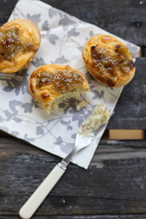 gooseberry friands with a bite taken out on a napkin with a fork on a wooden table