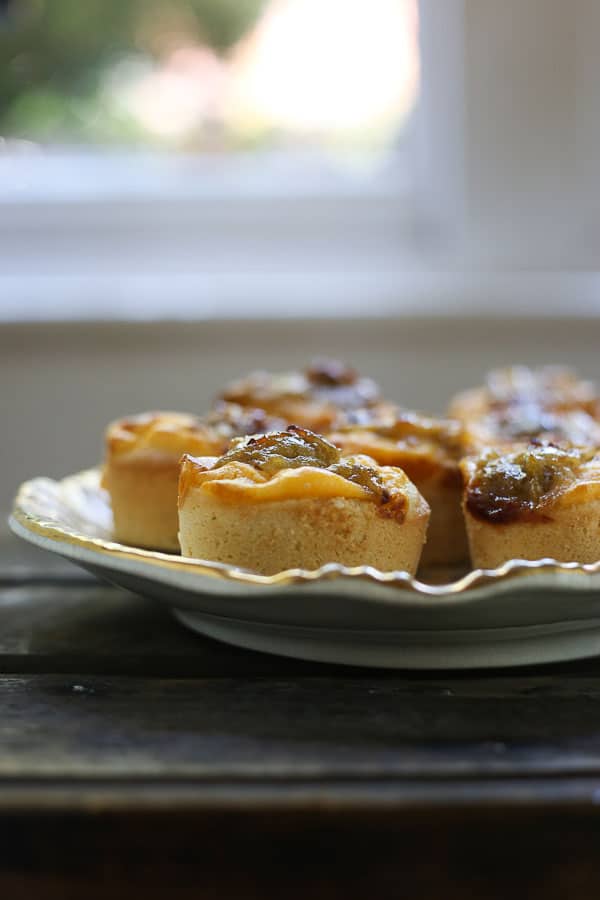 gooseberry friands on a plate on a wooden table in front of a window