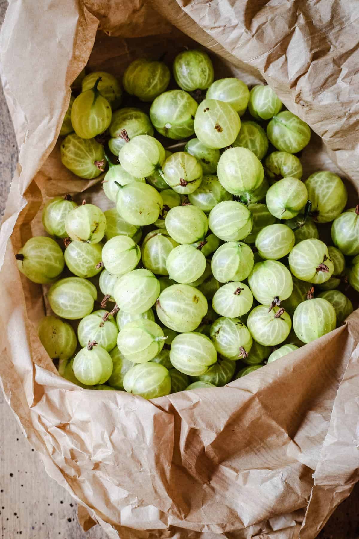 Fresh gooseberries in a paper bag.