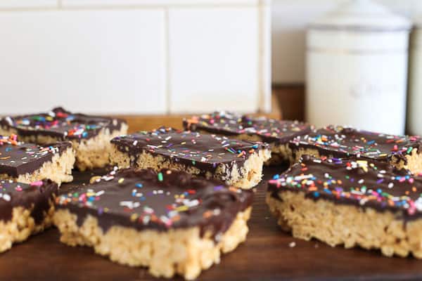 Side shot of Chocolate Peanut Butter Crispy Bars on a wooden board