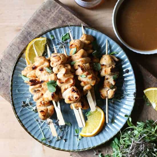Honey Orange & White Wine Skewers Honey Orange & White Wine Chicken Skewers on a plate with oranges, microherbs next to a bowl of marinade and a jar of honey