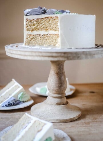 Best Gluten-Free Vanilla Cake on a cake stand on a wooden table