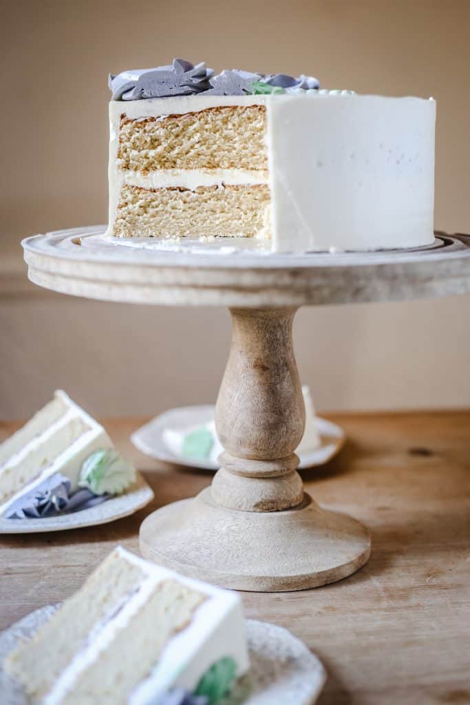 Best Gluten-Free Vanilla Cake on a cake stand on a wooden table