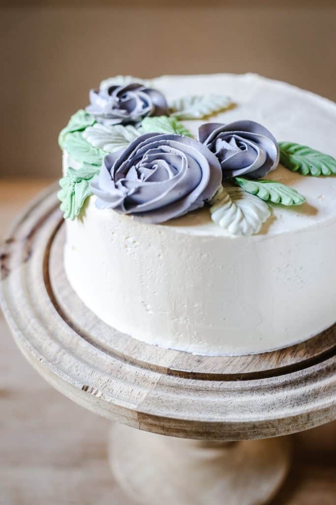Best Gluten-Free Vanilla Cake on a cake stand on a wooden table
