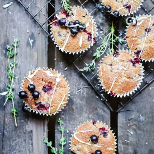 overhead of Blackcurrant White Chocolate and Thyme Muffins on a wooden table