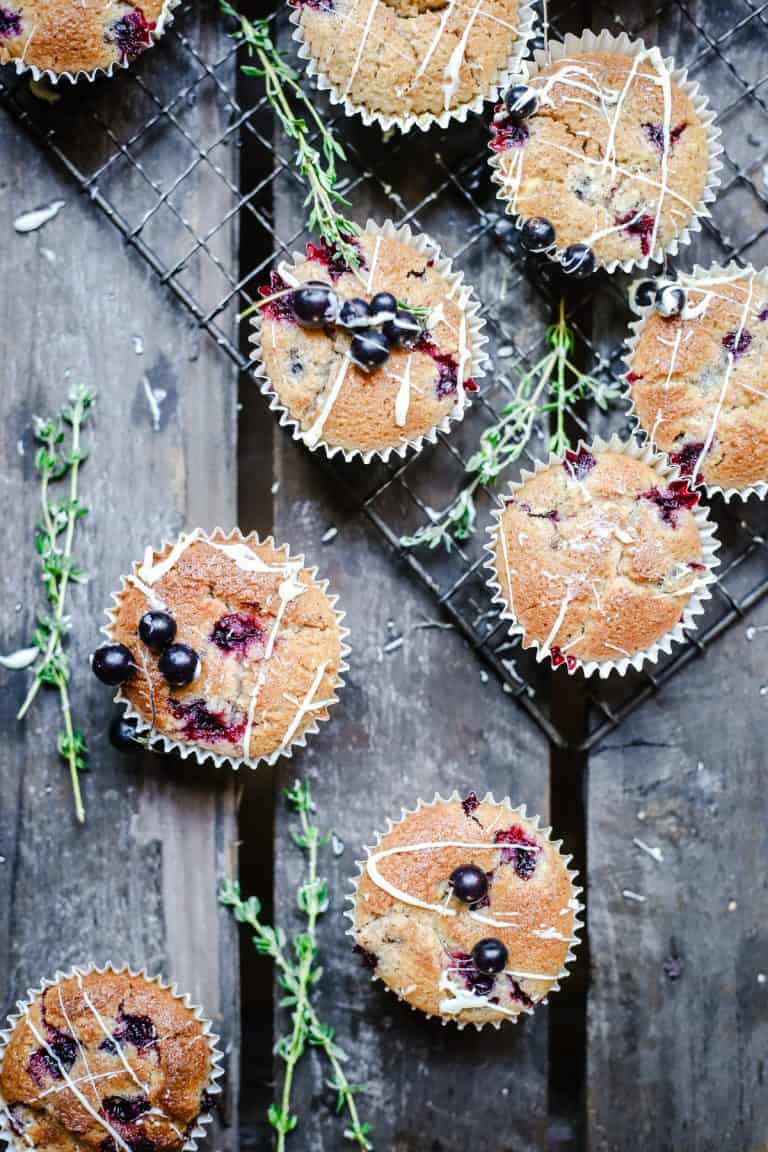 overhead of Blackcurrant White Chocolate and Thyme Muffins on a wooden table