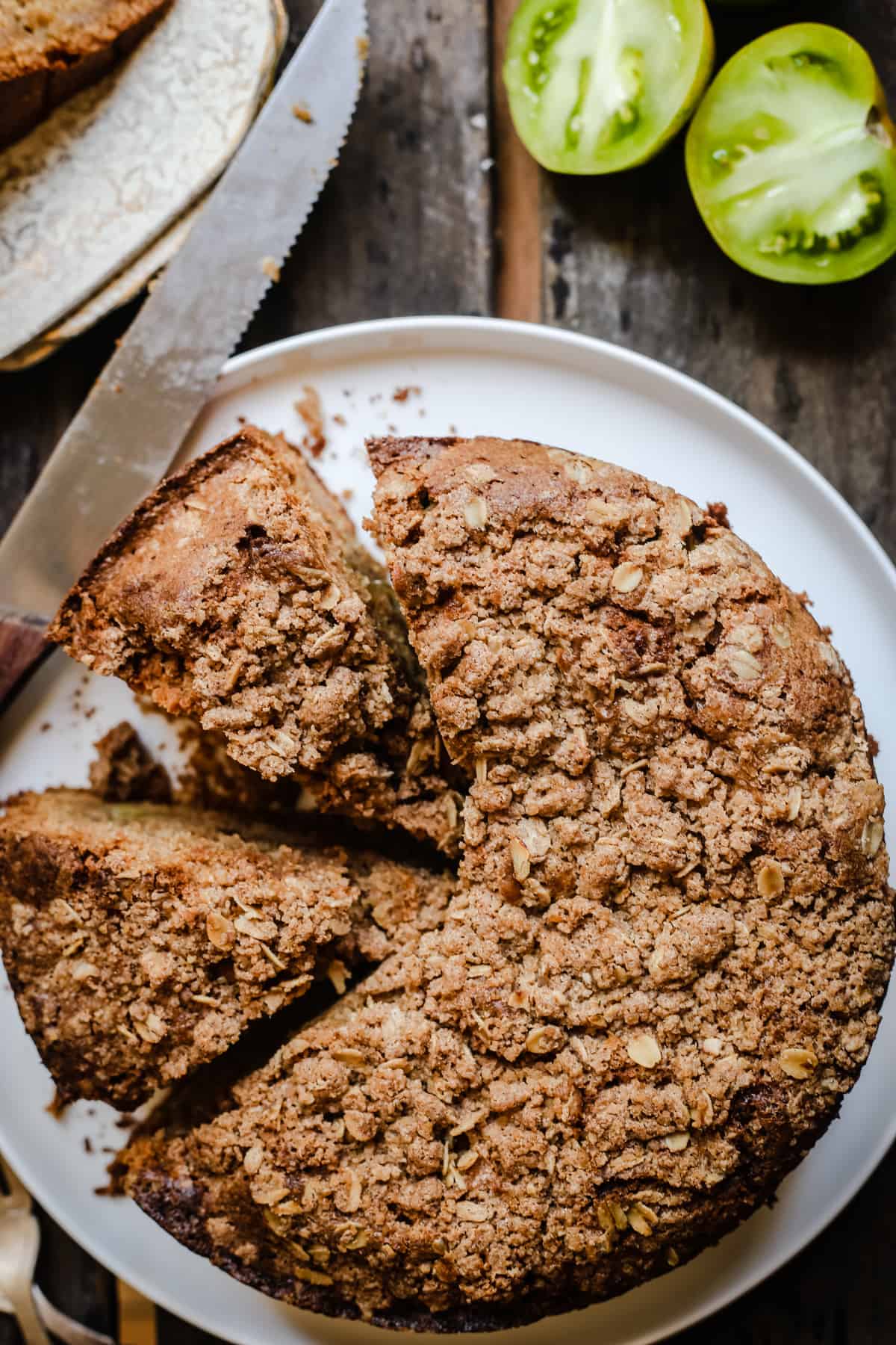 overhead shot of Green Tomato and Stem Ginger Cake with Streusel Topping {gluten-free} on a plate with green tomatoes next to it