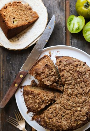 overhead shot of Green Tomato and Stem Ginger Cake with Streusel Topping {gluten-free} on a plate with green tomatoes next to it