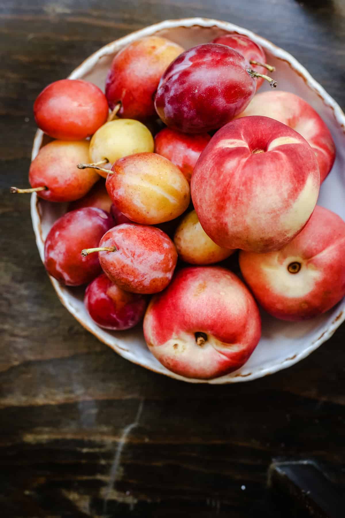 overhead shot of plums and nectarines in a bowl