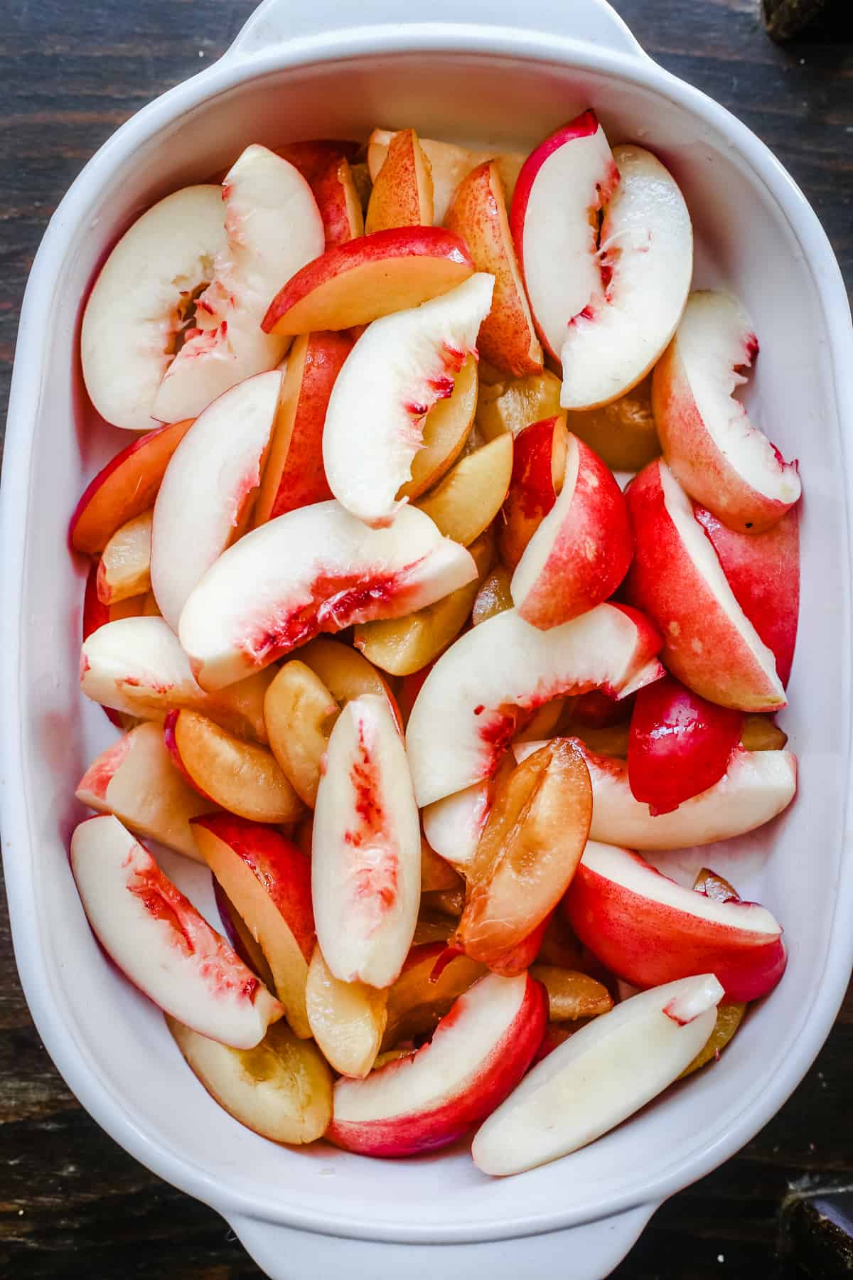 overhead shot of plums and nectarines in a baking dish