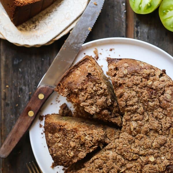 Green Tomato and Stem Ginger Cake with Streusel Topping {gluten-free} overhead shot of Green Tomato and Stem Ginger Cake with Streusel Topping {gluten-free} on a plate with green tomatoes next to it