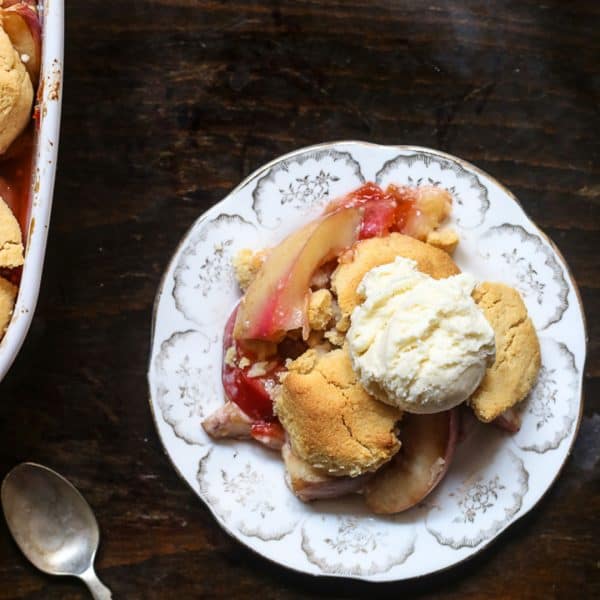 Plum Nectarine Cornbread Cobbler {gluten-free} overhead shot of a plate of plum nectarine cornbread cobbler on a table next to a spoon