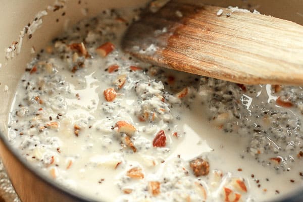 Grain-Free Coconut Chia Porridge being stirred in a saucepan