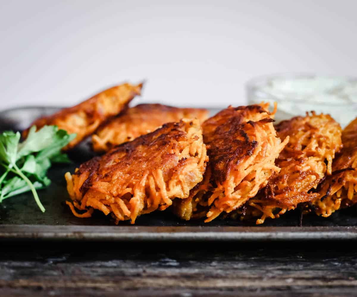 Sweet Potato Rosti with Bacon on a baking tray with dip.