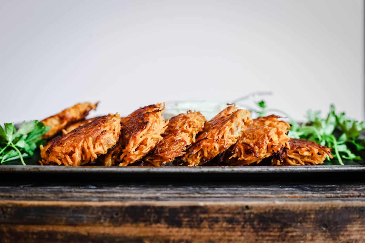 Sweet Potato Rosti with Bacon on a baking tray with dip.