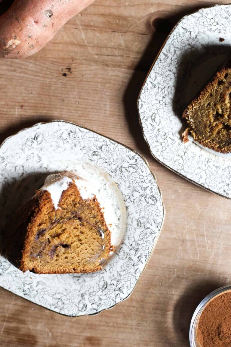 overhead shot of slices of Sweet Potato Cinnamon Swirl Cake on a plate with a sifter and sweet potatoes
