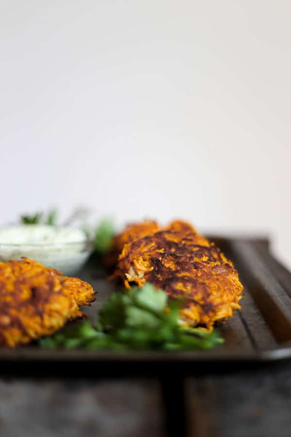 straight on shot of Sweet Potato and Bacon Rosti on a metal tray with tahini sauce