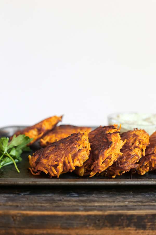 straight on shot of Sweet Potato and Bacon Rosti on a metal tray with tahini sauce