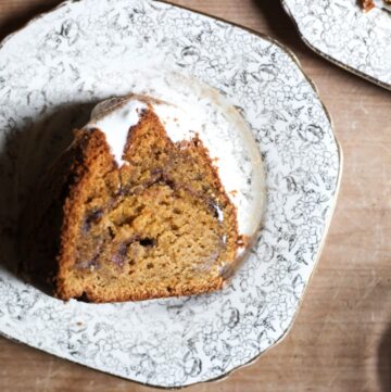 overhead shot of slices of Sweet Potato Cinnamon Swirl Cake on a plate with a sifter and sweet potatoes