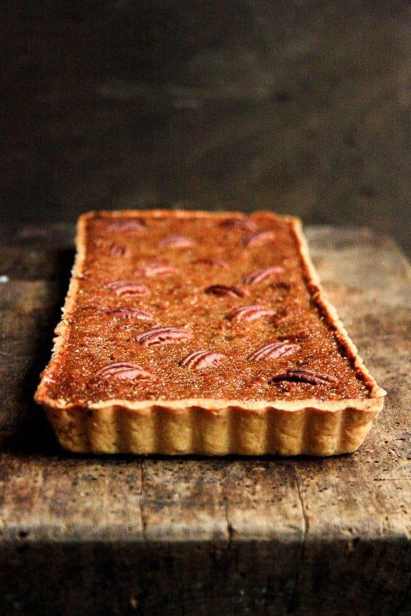 A close up of pecan treacle tart on wooden table