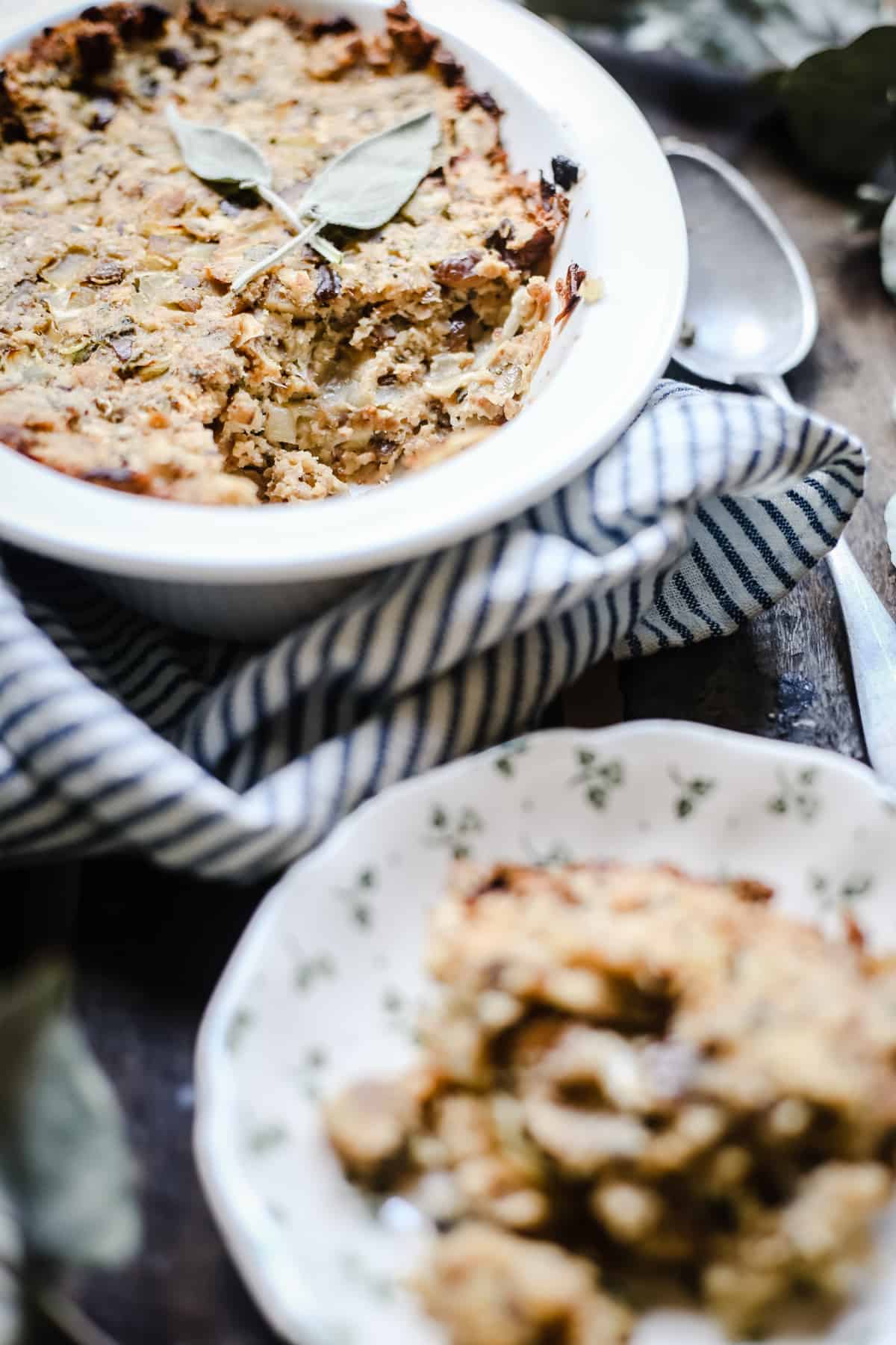 A dish of stuffing in the background with a plate of stuffing in front