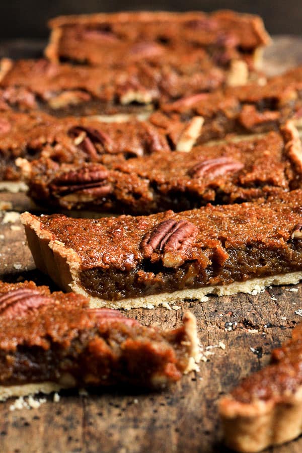 A close up of a slices of pecan treacle tart on wooden table