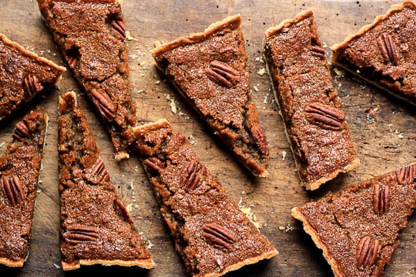 A close up of a slices of pecan treacle tart on wooden table