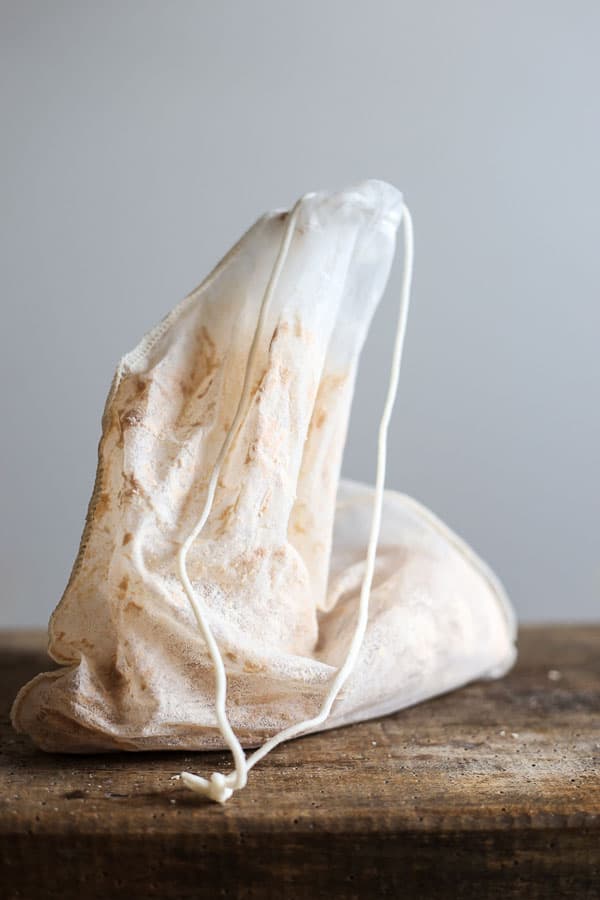 A nut milk bag full of soaked almond meal