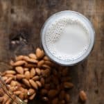 overhead of almond milk in front of almonds