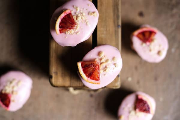 overview of Blood Orange Buckwheat Hazelnut Friands resting on a wooden box