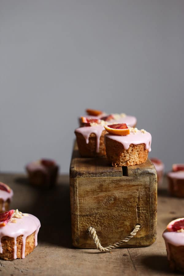 Blood Orange Buckwheat Hazelnut Friands resting on a wooden box with a few next to it