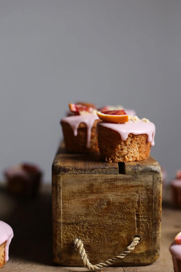 Blood Orange Buckwheat Hazelnut Friands resting on a wooden box with a few next to it