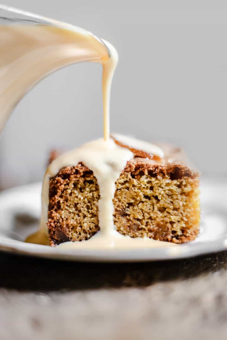 Lemon and Ginger Cake on a plate being drizzled with lemon custard