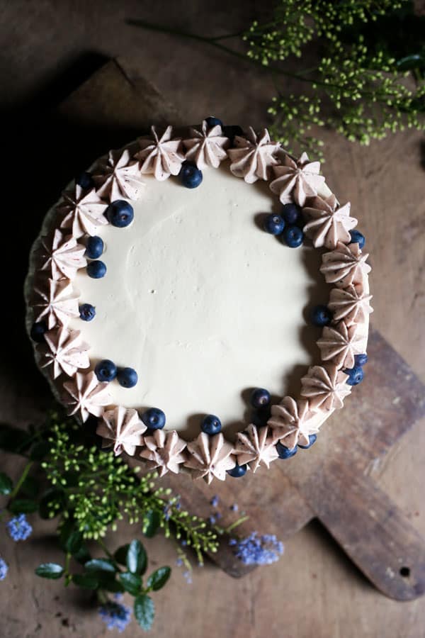 Apple Blueberry Maple Cake on a wooden board surrounded by flowers