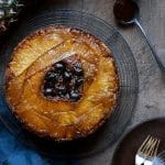 Overhead of Gluten-Free Pineapple Upside Down Cake with a pineapple and glass of caramel next to it.