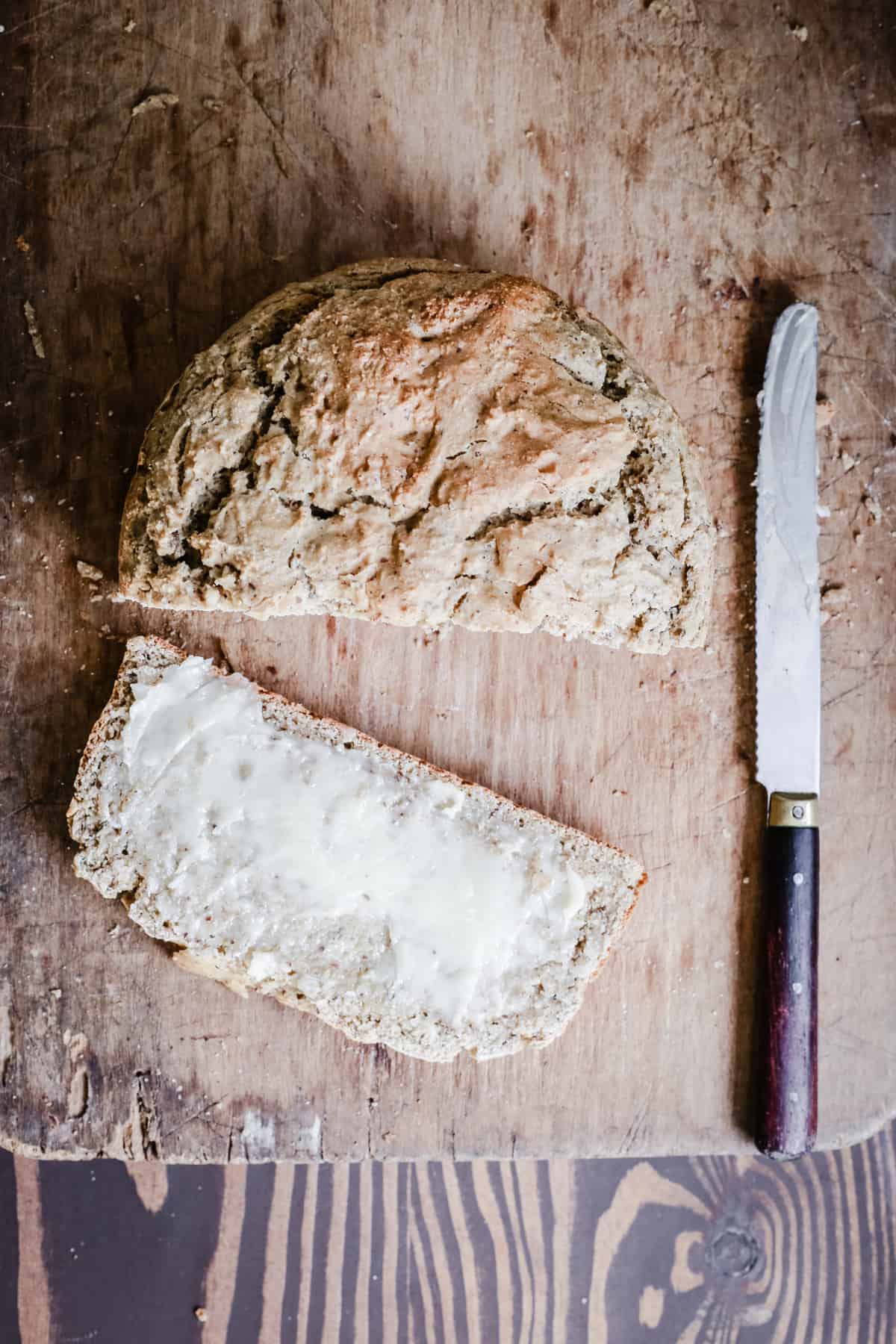 A slice of gluten-free irish soda bread on a bread board