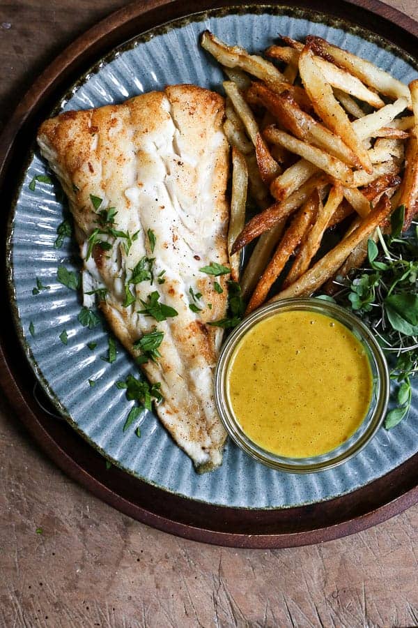 A plate of fish and chips with curry sauce