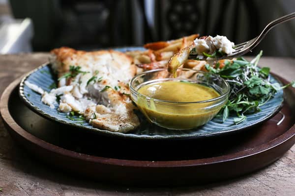 A plate of fish and chips with curry sauce