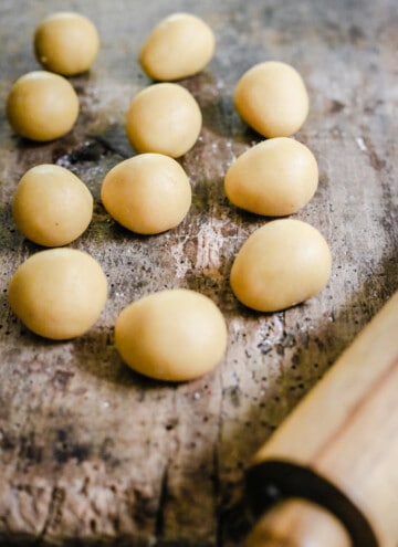 homemade marzipan dough rolled into balls on a wooden board