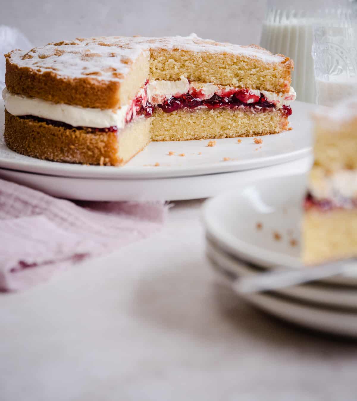 victoria sponge on a plate with slice cut out