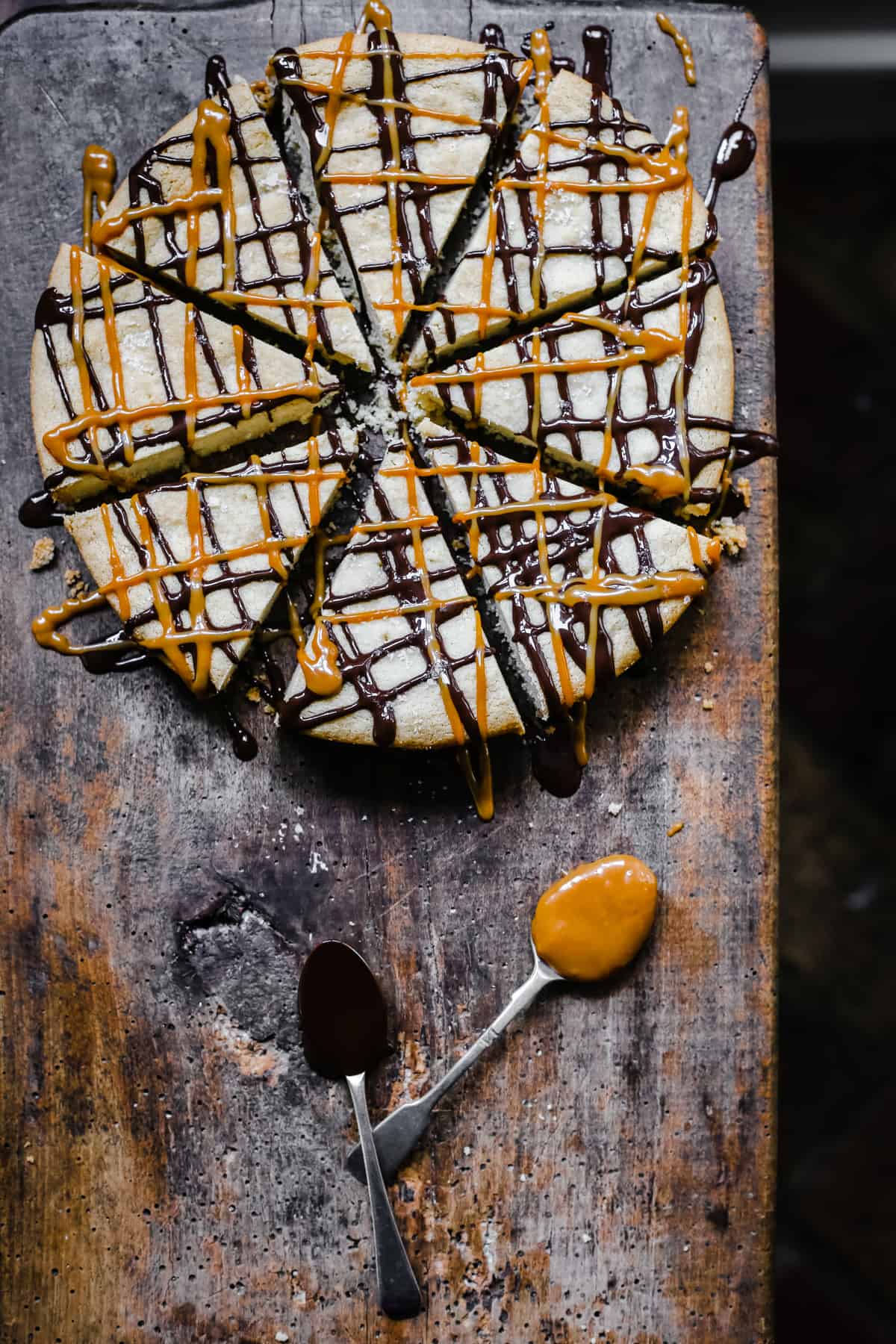 Gluten-free shortbread drizzled with chocolate and dulce de leche on wooden board