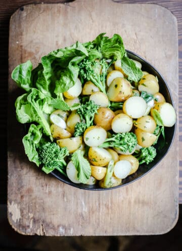 overhead view of a bowl of English Mint Potato Salad on a wooden board