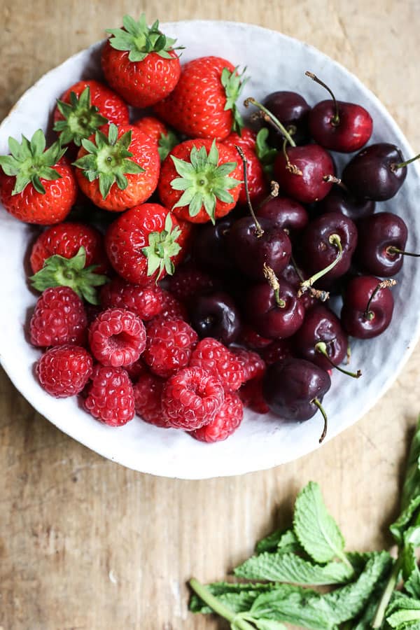 strawberries, raspberries, cherries in a bowl