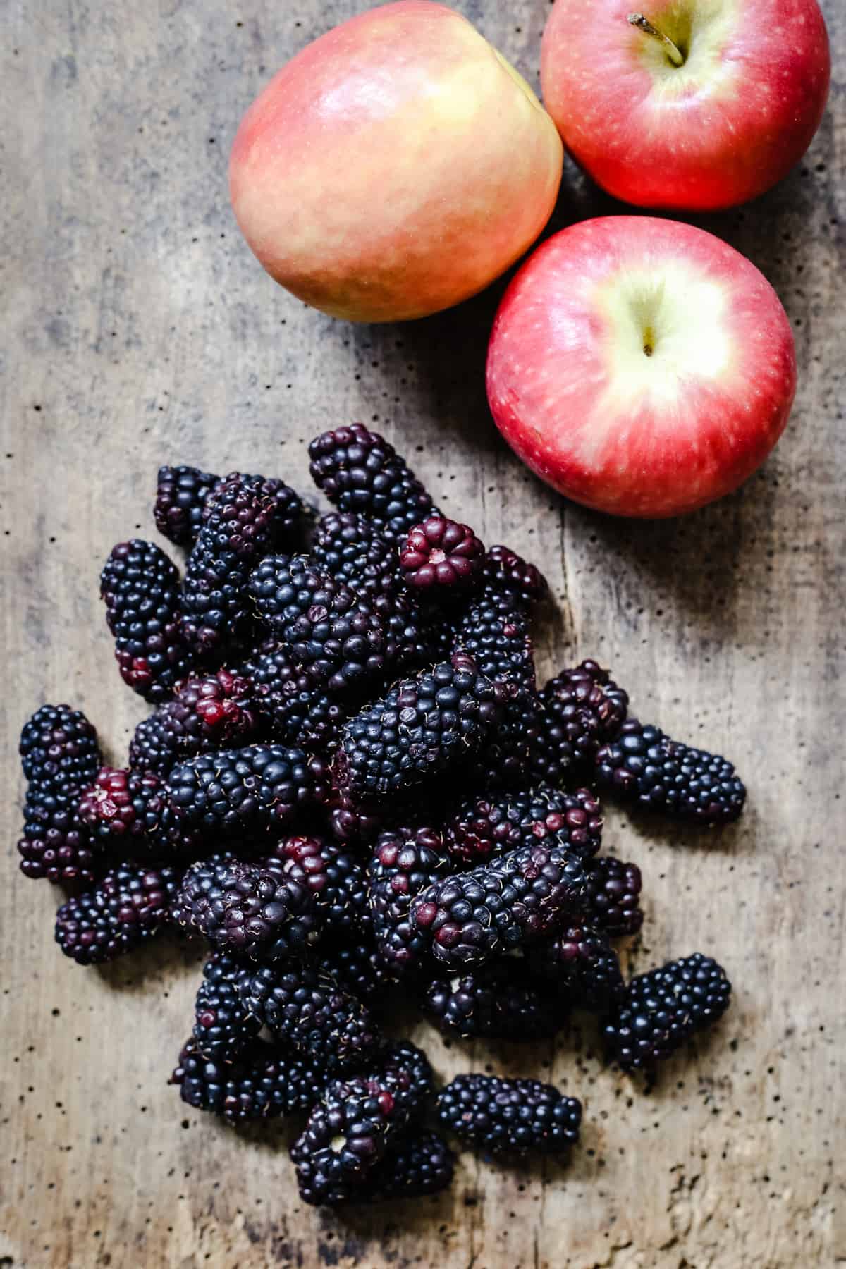 Blackberries and apple on a wooden board