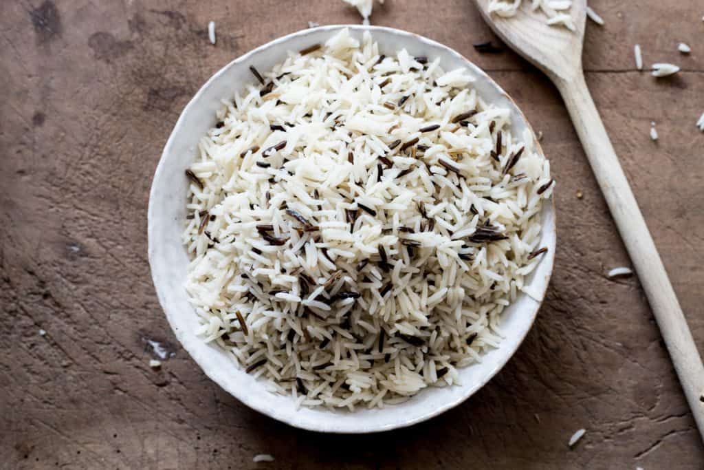 A bowl of basmati and wild rice on a wooden board