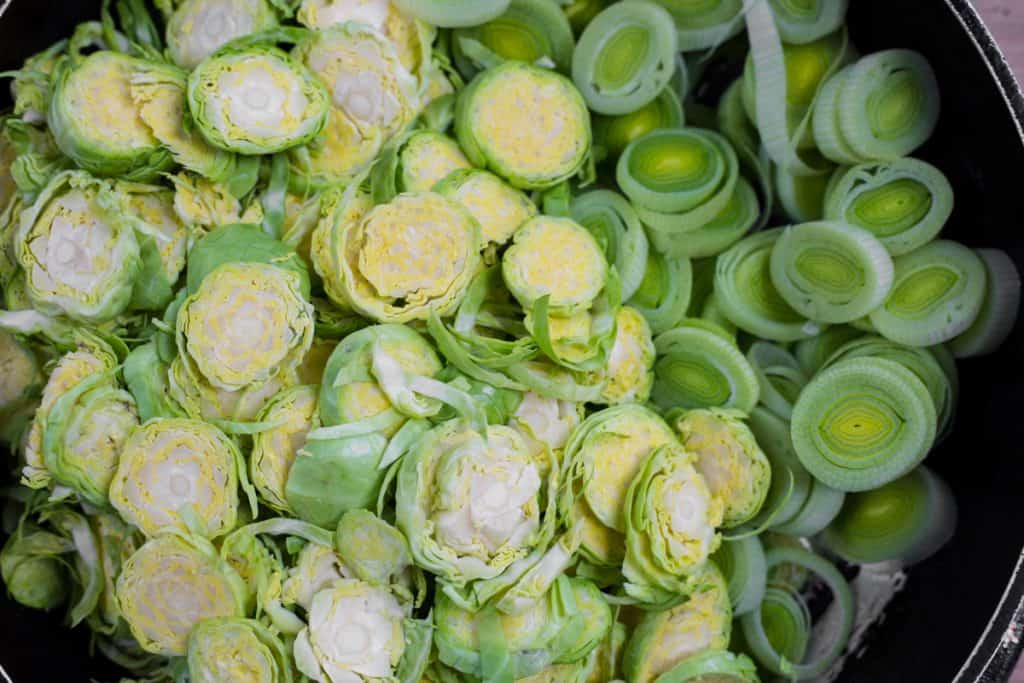 Shredded brussel sprouts and leeks in a pan